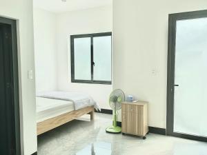 a bedroom with a bed and a fan and a window at Nhà Nghĩ Bà Rịa - Bình An in Ấp Nam
