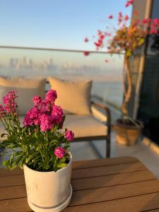 アブダビにあるLuxury Saadiyat Fully Equipped Apartmentのピンクの花のテーブルに座る鉢