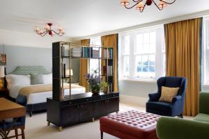 a bedroom with a bed and a room with a mirror at University Arms, Autograph Collection in Cambridge