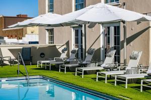 a group of chairs and umbrellas next to a pool at The Lindy Renaissance Charleston Hotel in Charleston