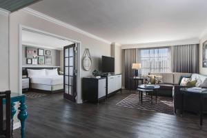 a hotel room with a bed and a living room at The Lindy Renaissance Charleston Hotel in Charleston