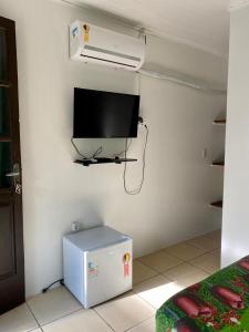 Camera con TV a parete e frigorifero. di Hospedaria aconchego 5 a Garopaba Altre 2 foto