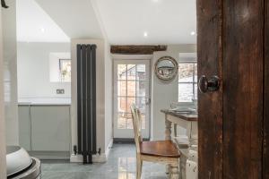 a kitchen with a wooden table and a chair at Eilmers Cottage - Beautiful 4BD in Malmesbury! in Malmesbury +197 photos