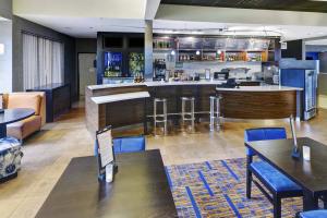 a restaurant with a bar with blue chairs and tables at Courtyard Chicago Glenview/Northbrook in Glenview