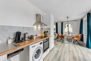a kitchen with a washer and dryer and a table at Familienfreundliches Apartment zwischen Potsdam und Berlin für 2-4 Personen - Parkplatz - Balkon - Voll ausgestattete Küche - WLAN - Ferienwohnung Nebelwiesen Stahnsdorf in Stahnsdorf
