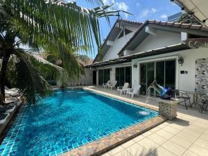 奈扬海滩The Snug Airportel - Phuket Airport的房子前面的游泳池