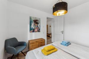 a bedroom with a bed and a blue chair at Familienfreundliches Apartment zwischen Potsdam und Berlin für 2-4 Personen - Parkplatz - Balkon - Voll ausgestattete Küche - WLAN - Ferienwohnung Nebelwiesen Stahnsdorf in Stahnsdorf