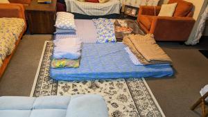 un soggiorno con divano e letto blu di BIDWILL GARDENS ON MIDDLETON - Private Room King-Size Bed or Open Lounge Room Floor Mattress SHARED Bathroom FREE Kitchen Essentials FREE Laundry Facilities Fast NBN WIFI HDTV NETFLIX, YOUTUBE, KAYO Private Transport and Meal Services Available On Request a Bidwill Altre 22 foto