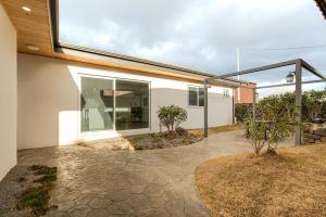 a house with a large window on the side of it at Jeju Stone Courtyard Pension in Jeju