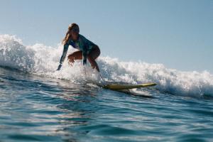 a woman riding a wave on a surfboard in the ocean at Nattivo Chacahua in Guayabas