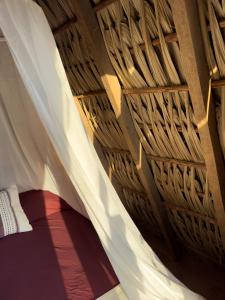 a room with a wooden ceiling with white curtains at Nattivo Chacahua in Guayabas +29 photos