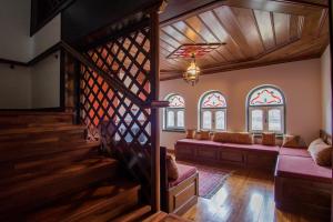 a living room with a staircase and stained glass windows at Hotel Petrotechno in Tsepelovo