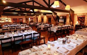 a dining room filled with tables and chairs with white linens at Kingsleigh Apartments Sydney in Sydney
