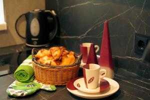 a basket of food on a counter with cups and plates at Elen Apartments in Ezermala
