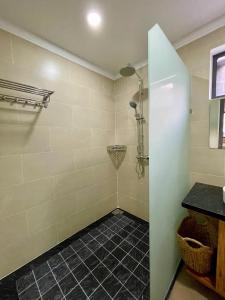 富国Royal villa的浴室铺有黑色瓷砖地板,设有淋浴。