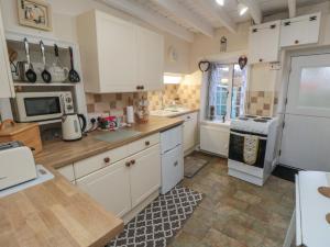 a kitchen with white cabinets and a stove top oven at 31 Outgang Road in Pickering