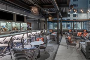 a restaurant with chairs and tables and a bar at AC Hotel by Marriott Atlanta Midtown in Atlanta