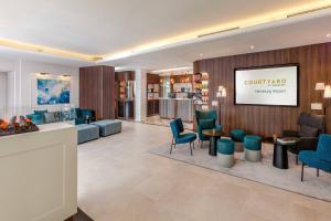 a lobby with blue chairs and a living room at Courtyard by Marriott Hamburg Airport in Hamburg