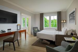 a hotel room with a bed and a desk at Courtyard by Marriott Hamburg Airport in Hamburg