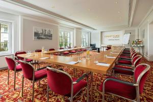 a large conference room with a long table and chairs at Courtyard by Marriott Hamburg Airport in Hamburg