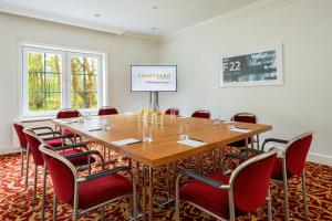 a conference room with a wooden table and chairs at Courtyard by Marriott Hamburg Airport in Hamburg