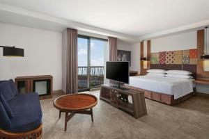 a bedroom with a bed and a tv and a couch at Fairfield by Marriott Bali South Kuta in Kuta