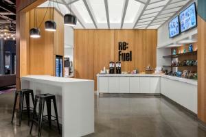 a restaurant with a counter and stools in a room at Aloft Chicago Schaumburg in Rolling Meadows