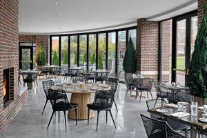 a restaurant with tables and chairs and windows at The Lytle Park Hotel, Autograph Collection in Cincinnati