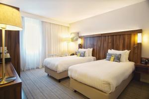 a hotel room with two beds and a lamp at Courtyard by Marriott Glasgow Airport in Paisley