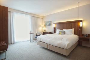 a hotel room with a large bed and a window at Courtyard by Marriott Glasgow Airport in Paisley