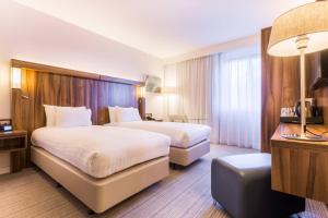 a hotel room with two beds and a desk at Courtyard by Marriott Glasgow Airport in Paisley