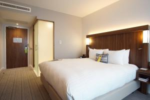 a large white bed in a hotel room at Courtyard by Marriott Glasgow Airport in Paisley