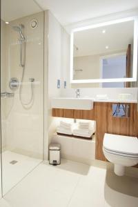 a bathroom with a shower and a toilet and a sink at Courtyard by Marriott Glasgow Airport in Paisley