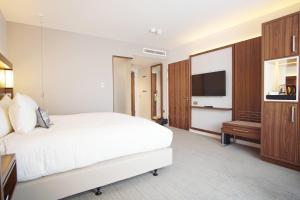 a hotel room with a bed and a flat screen tv at Courtyard by Marriott Glasgow Airport in Paisley