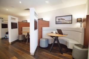 a room with a bed and a table with a laptop on it at Courtyard by Marriott Glasgow Airport in Paisley