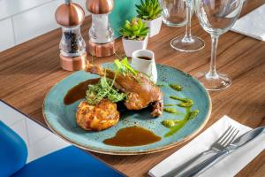 a blue plate of food on a wooden table at Courtyard by Marriott Glasgow Airport in Paisley