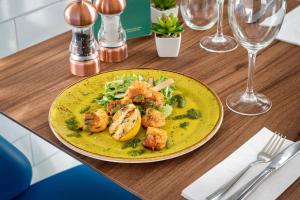 a plate of food with shrimp and vegetables on a table at Courtyard by Marriott Glasgow Airport in Paisley