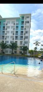 un grand bâtiment avec une piscine en face d'un bâtiment dans l'établissement Seawind Damosa Condominium, à Davao 2 autres photos