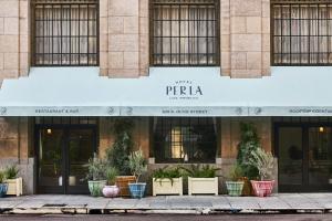 a facade of a building with potted plants on the sidewalk at Hotel Per La, Autograph Collection in Los Angeles