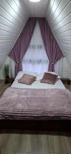 a bedroom with a large bed in a tent at Casuta de la ferma in Băiculeşti