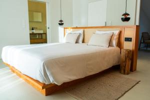 a bedroom with a large bed with white sheets and pillows at Silveira Bay Lounge Retreat in Angra do Heroísmo