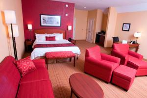 a hotel room with a bed and red furniture at Courtyard Middlebury in Middlebury +25 photos