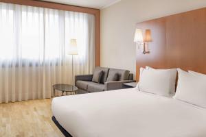 a hotel room with a large white bed and a couch at AC Hotel Genova by Marriott in Genoa