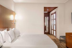 a bedroom with a white bed with white pillows at AC Hotel Genova by Marriott in Genoa