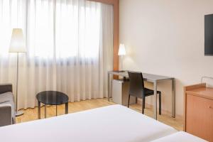 a hotel room with a bed and a desk and chair at AC Hotel Genova by Marriott in Genoa