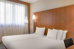 a large white bed in a hotel room at AC Hotel Genova by Marriott in Genoa