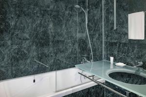 a bathroom with a sink and a bath tub at AC Hotel Genova by Marriott in Genoa