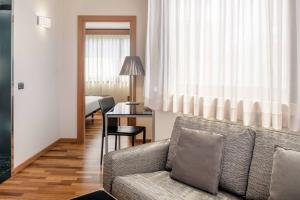 a living room with a couch and a table at AC Hotel Genova by Marriott in Genoa