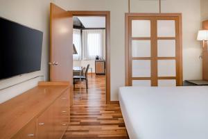 a bedroom with a bed and a tv and a table at AC Hotel Genova by Marriott in Genoa