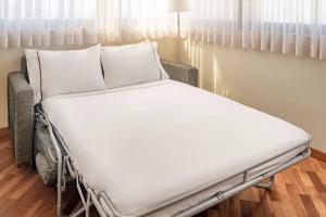 a hospital bed with white sheets and pillows at AC Hotel Genova by Marriott in Genoa